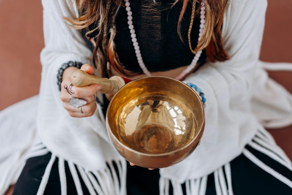 pexels-photo-6932022-6932022 A woman holding a singing bowl, engaging in a peaceful meditation practice.