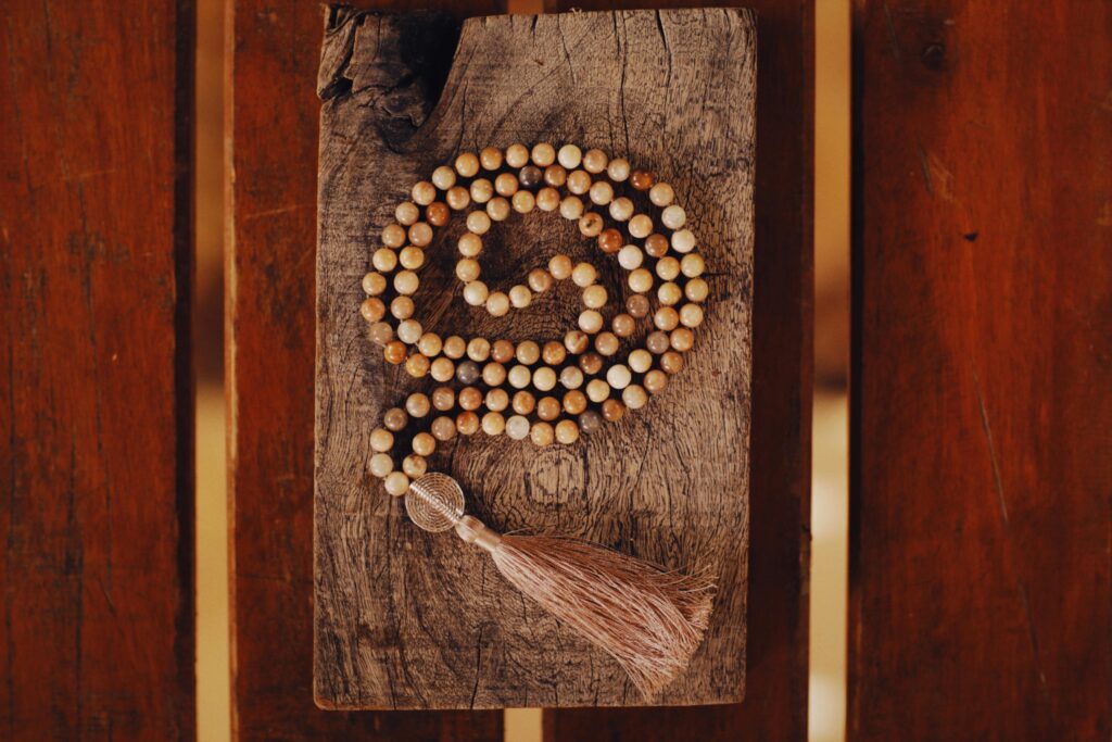 Wooden prayer beads arranged on rustic wood, conveying meditation.